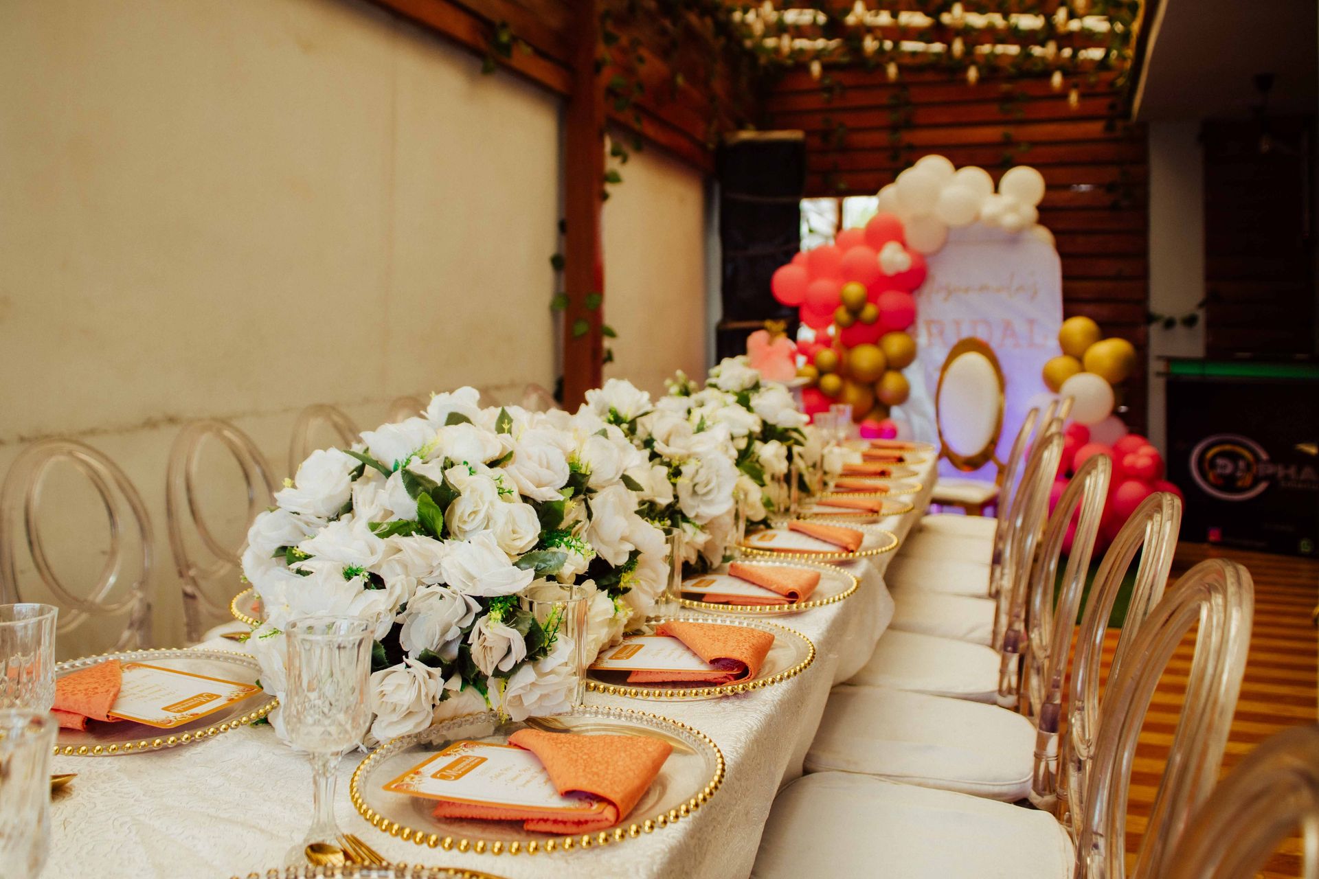Elegant bridal shower table setting with white flowers, balloons, and golden accents.