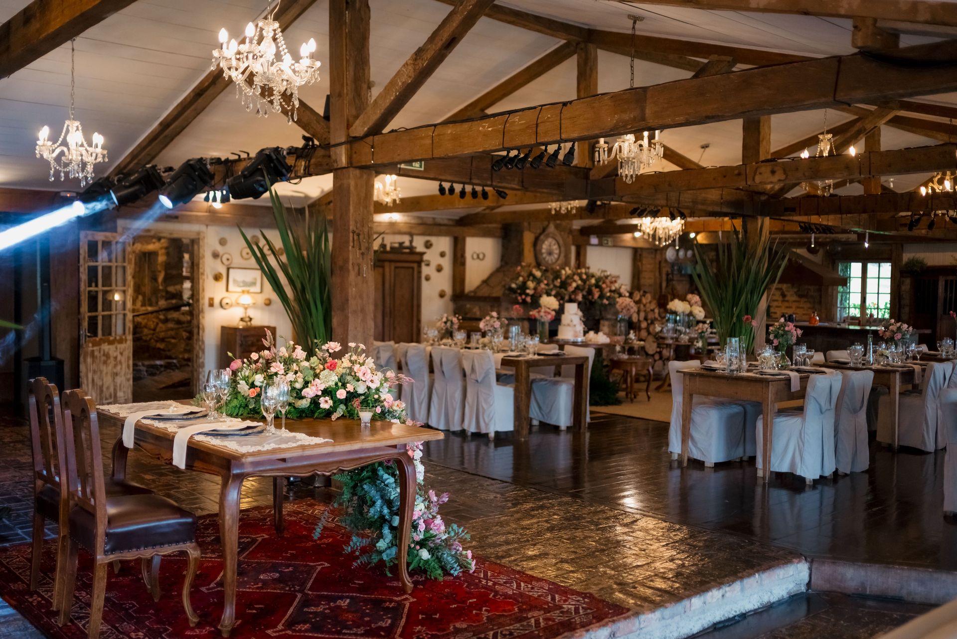 Beautiful rustic wedding reception with elegant floral arrangements and romantic lighting indoors.